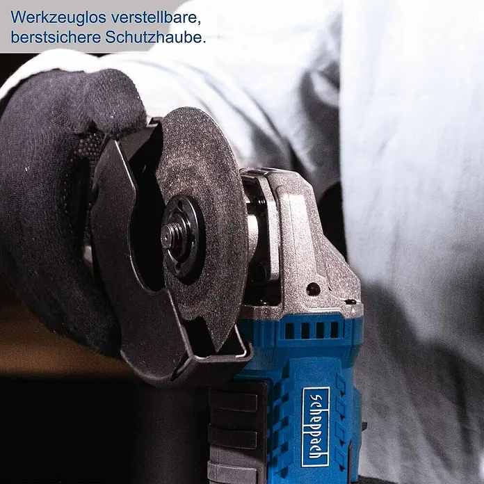 Scheppach IXES 20V Akku-Winkelschleifer C-ATB15/1-X - 1 Akku, 4 Ah, Durchmesser Scheibe: 125 mm - Eine Person mit schwarzem Handschuh hält einen blau-silbernen Winkelschleifer mit schwarzer Scheibe und werkzeuglos verstellbarer, berstsicherer Schutzhaube.