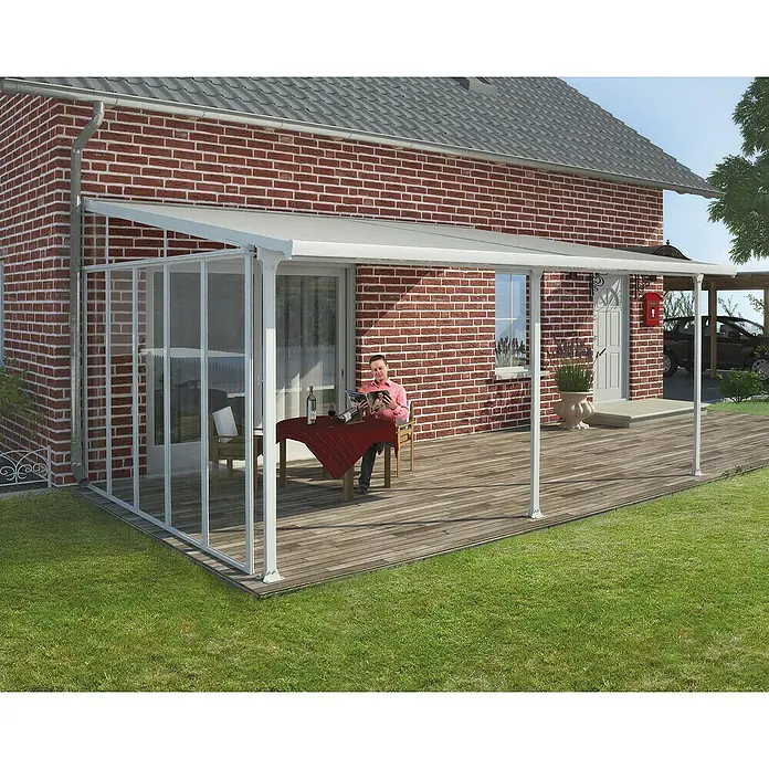 Palram – Canopia Seitenwand - Weiß, Passend für: Palram – Canopia Terrassenüberdachungen 4m Tiefe - Weißes Terrassendach mit transparenten Seitenwänden am Ziegelhaus über einem Holzdeck. Eine Person liest darunter.