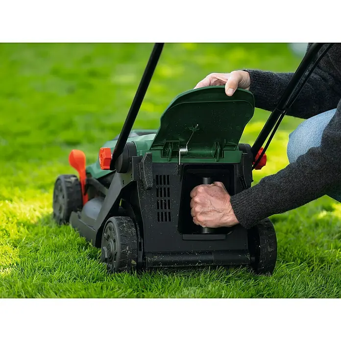 Bosch Power for All 18V Akku-Rasenmäher ROTAK18V-32 - Ohne Akku, Schnittbreite: 32 cm - Person stellt einen grün-schwarzen Rasenmäher ein und öffnet ein Fach, um das Innere zu erreichen.