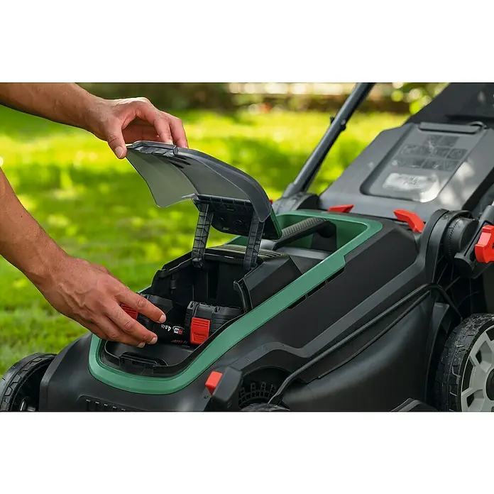 Bosch Power for All 18V Akku-Rasenmäher ROTAK18V2-43 - Ohne Akku, Schnittbreite: 43 cm - Hände legen einen 4,0 Ah Akku in einen schwarz-grünen Akku-Rasenmäher ein.