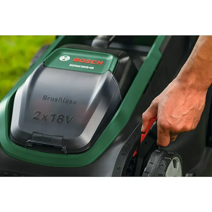 Bosch Power for All 18V Akku-Rasenmäher ROTAK18V2-43 - Ohne Akku, Schnittbreite: 43 cm - Grüner Bosch Rotak Rasenmäher, 'Brushless 2x18V' sichtbar, eine Hand verstellt den roten Schnitthöhenhebel.