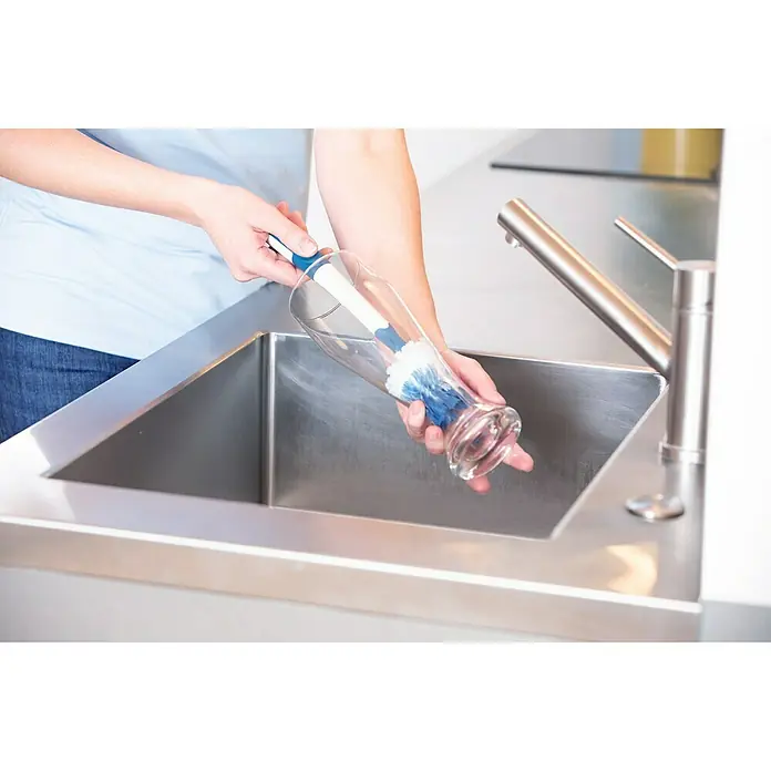 Unger Spülbürste Flex - 32 cm, Kunststoff/Gummi - Eine Person reinigt ein Glas mit einer Flaschenbürste in einem Edelstahlspülbecken, um Sauberkeit und Hygiene in der Küche zu gewährleisten.
