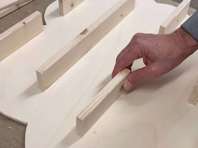 Holzplatten werden an die große Holzplatte in Wolkenform im 90°-Winkel angeschraubt