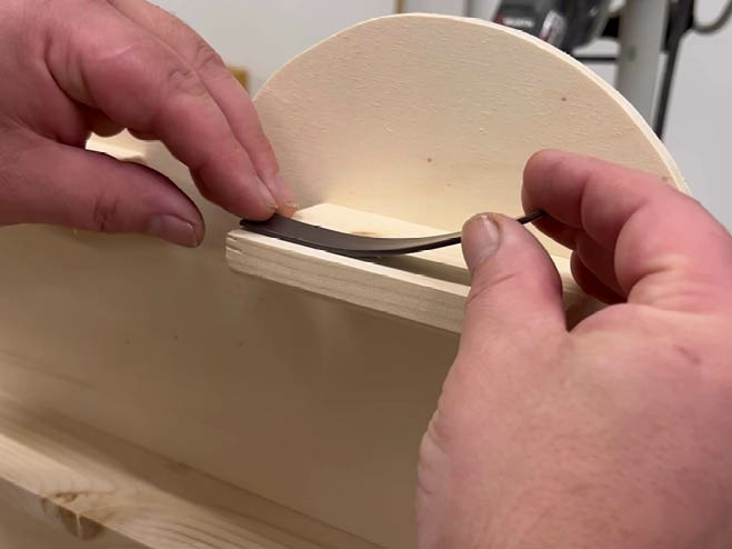 Ein Magnetband wird auf eine Holzplatte geklebt