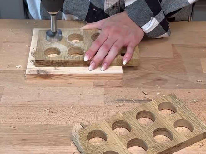 Große Löcher werden in 2 der Holzplatten gebohrt