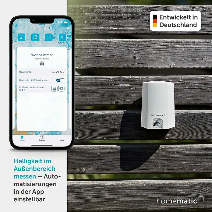 Homematic IP Funk-Lichtsensor HmIP-SLO - Weiß, 5,2 x 6,5 x 3,4 cm, Batteriebetrieben - Weißer Homematic Außensensor an einem Holzzaun, Smartphone zeigt App zur Steuerung von Smart-Home-Funktionen.