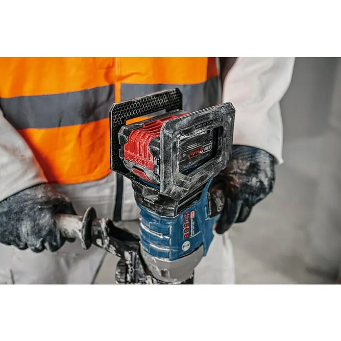 Bosch Professional Akku-Rührwerk GRW 18V-120 - 18 V, Anzahl Akkus: Ohne Akku - Ein Arbeiter bedient einen staubigen blauen und roten Bosch Akku-Mischer mit sichtbarem Akku.