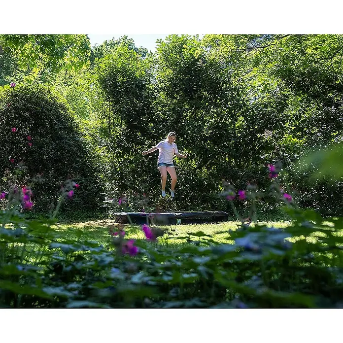 Exit Toys Trampolin Silhouette Sports - Durchmesser: 305 cm, Schwarz - Mädchen springt auf einem schwarzen Bodentrampolin.