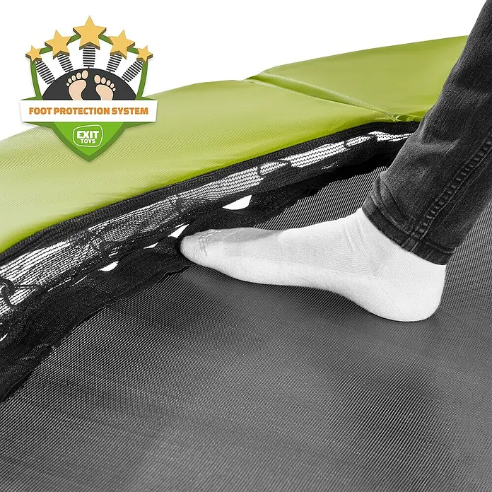 Exit Toys Trampolin Silhouette - Durchmesser: 244 cm, Grün - Fuß in Socke auf Trampolinmatte, neben grüner Schutzabdeckung und schwarzem Sicherheitsnetz des 'Foot Protection System'.