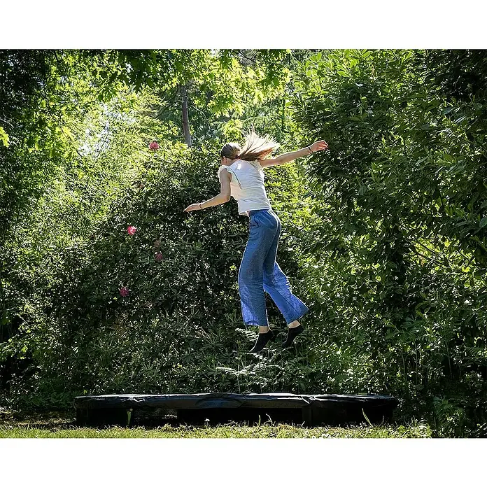 Exit Toys Trampolin Silhouette Sports - Durchmesser: 244 cm, Schwarz - Schwarzes Trampolin, auf dem eine Person im Freien springt.