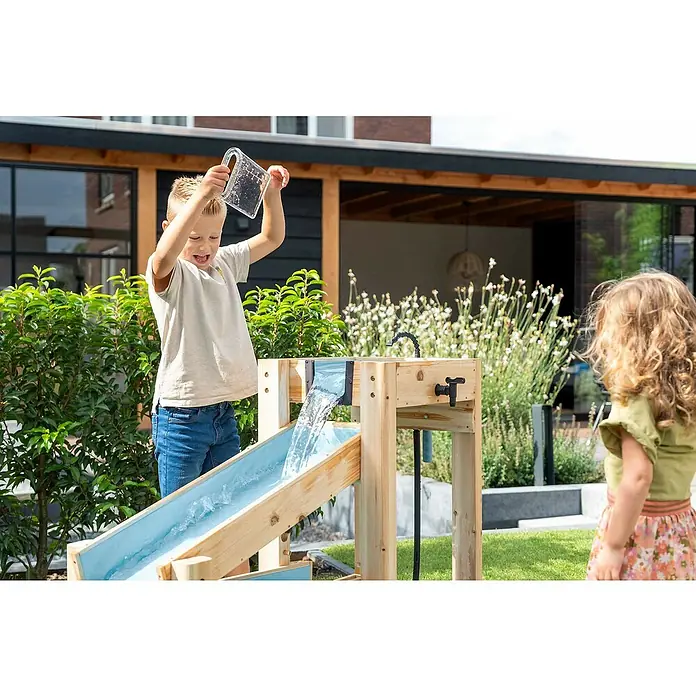 Exit Toys Wasserbahn Aquaflow - Holz, Natur/Blau, 140 x 73 x 90 cm - Hölzerner Wasser-Spieltisch mit blauen Rinnen; ein Junge gießt Wasser, während ein Mädchen zuschaut.