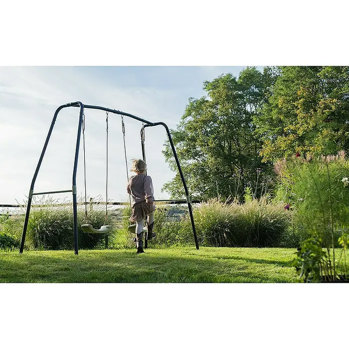 Exit Toys Schaukel Ivy - B x L: 243 x 110 cm, Metall - Dunkles Metallschaukelset mit zwei Sitzen, von einem Kind im Garten genutzt.