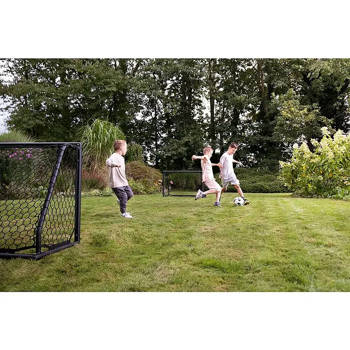 Exit Toys Fußballtor Scala - 120 x 55 x 80 cm, Schwarz - Zwei schwarze, tragbare Fußballtore werden von Kindern beim Fußballspielen im Garten genutzt.