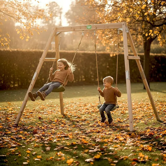 Exit Toys Schaukel Silvi Duo - B x L: 192 x 247 cm, Holz - Hölzerne Schaukel mit zwei Kindern, die in einem Herbstgarten spielen.