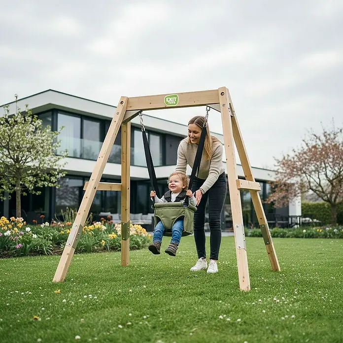Exit Toys Schaukel Silvi Grow - B x L: 192 x 172 cm, Holz - Ein Kind in einer grünen Babyschaukel, Teil einer Holzschaukel, wird von einem Erwachsenen sanft angeschoben.