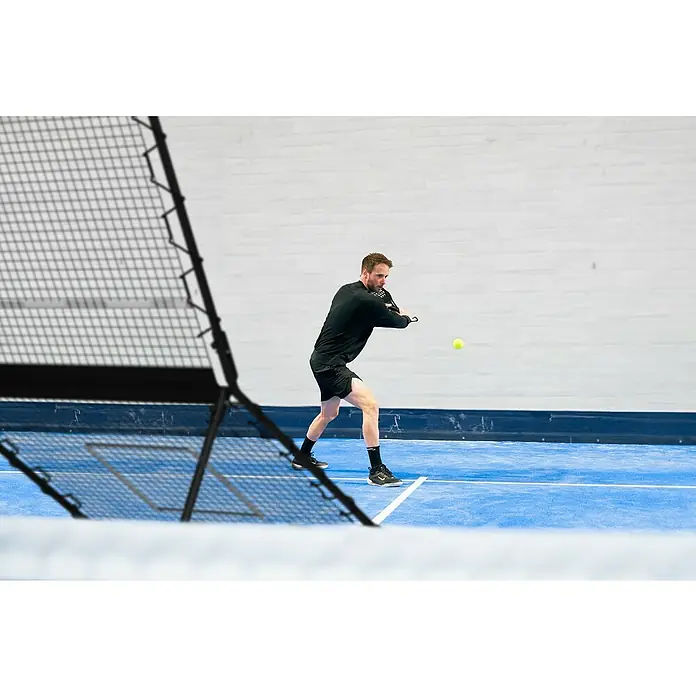 Exit Toys Sportnetz Smash Padel Rebounder - 164 x 124 x 202 cm, Stahl, Schwarz - Mann in schwarzer Sportkleidung spielt Padel, schlägt einen gelben Ball.