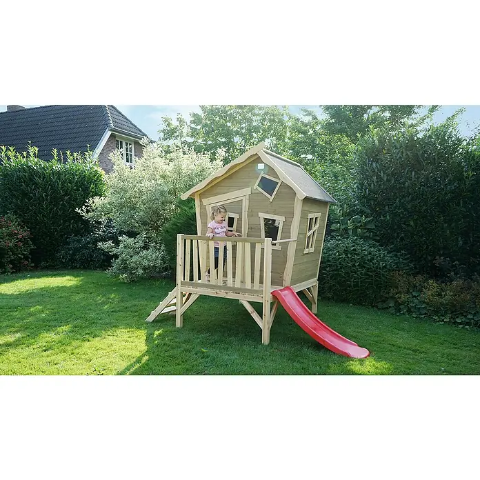 Exit Toys Spielhaus Crooky 300 - L x B x H: 269 x 184 x 227 cm, Holz, Grau/Beige - Ein kleines Mädchen steht in einem Holzspielhaus mit roter Rutsche in einem sonnigen Garten.
