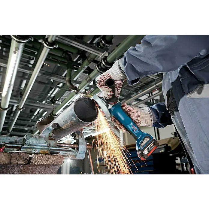 Bosch Professional AMPShare 18V Akku-Winkelschleifer GWS 18V-10 P PRO - 2 Akkus, Durchmesser Scheibe: 125 mm - Ein Arbeiter mit Handschuhen verwendet einen blauen Bosch 18V Akku-Winkelschleifer zum Trennen eines Metallrohrs, wobei Funken entstehen.