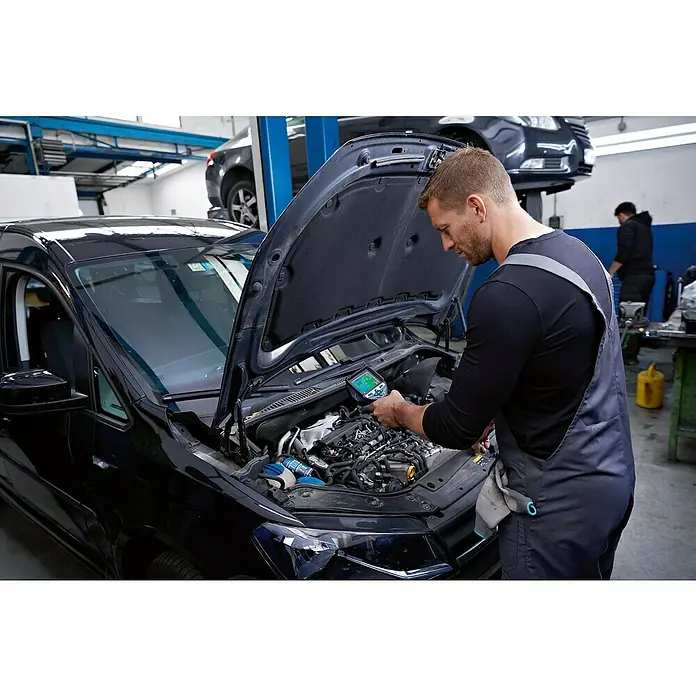 Bosch Professional Wärmebildkamera GTC 600 C PRO - Messbereich Temperatur: -20 °C - 600 °C - Mechaniker untersucht einen Automotor mit einem Handdiagnosegerät mit Display.