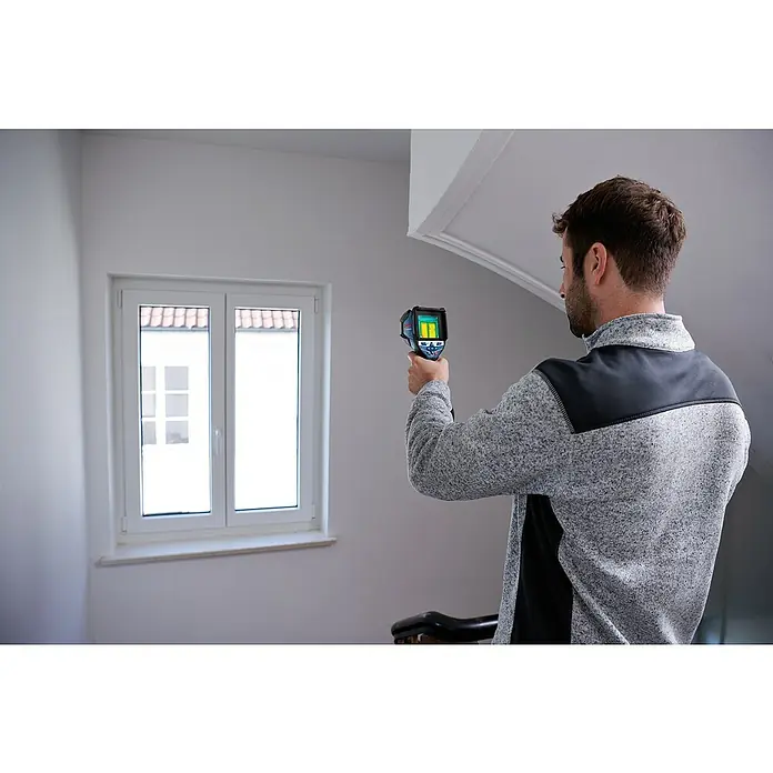 Bosch Professional Wärmebildkamera GTC 600 C PRO - Messbereich Temperatur: -20 °C - 600 °C - Mann inspiziert eine Zimmerwand mit einer schwarz-blauen Hand-Wärmebildkamera.