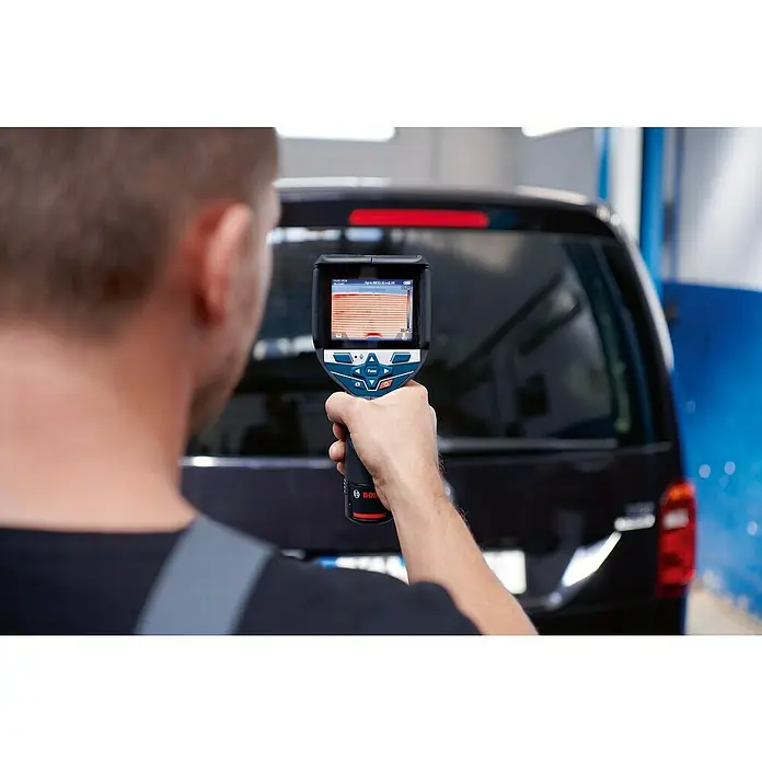Bosch Professional Wärmebildkamera GTC 600 C PRO - Messbereich Temperatur: -20 °C - 600 °C - Mann verwendet eine blau-schwarze Bosch Wärmebildkamera mit Wärmebildanzeige zum Scannen des Hecks eines dunklen Fahrzeugs.