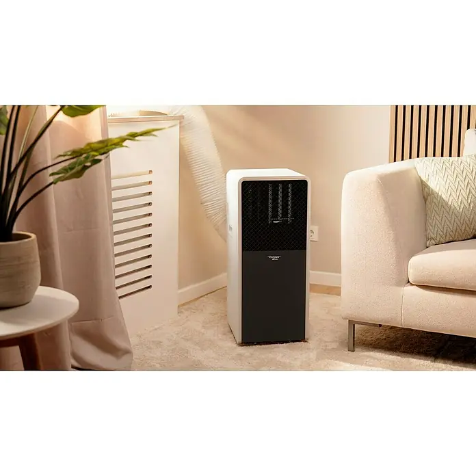 Voltomat Aire acondicionado portátil WiFi Khione I - 2.600 W, Tamaño de la estancia: 18 m² - 32 m², Negro/Blanco - Aire acondicionado portátil blanco y negro con tubo de escape en sala de estar, junto a un sofá beige.