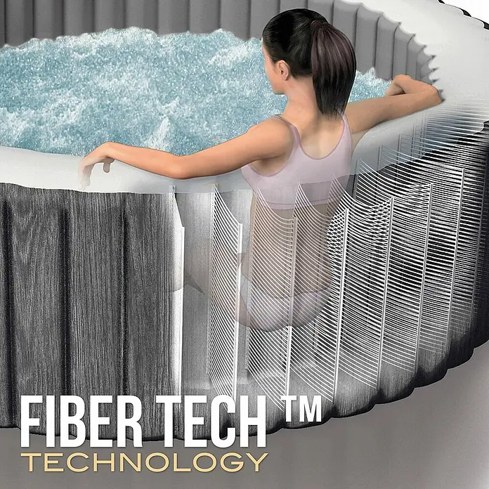 Intex Pure Spa Hidromasaje móvil Greenwood - Ø x Al: 216 x 71 cm, Gris/Blanco, 1.098 l - Bañera de hidromasaje con textura madera gris y borde blanco. Corte transparente revela estructura interna Fiber Tech. Mujer se relaja en agua burbujeante.