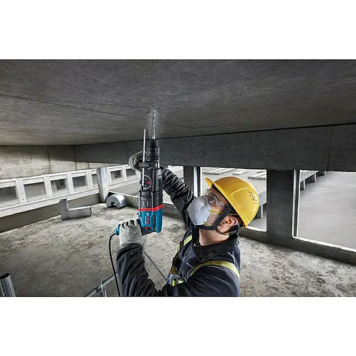 Bosch Professional Bohrhammer-Set GBH 2-26 F - 2,7 J - Arbeiter bohrt mit blau-schwarzem Bosch Bohrhammer in Betondecke.