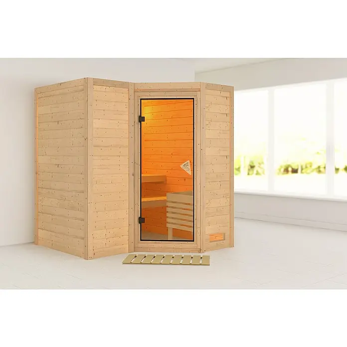 Karibu Massivholzsauna Sahib 1 - Ohne Ofen, Mit Dachkranz & Beleuchtung, L x B x H: 193 x 184 x 198 cm - Ecksauna aus hellem Holz mit Glastür, beleuchtetem Inneren und Bänken.