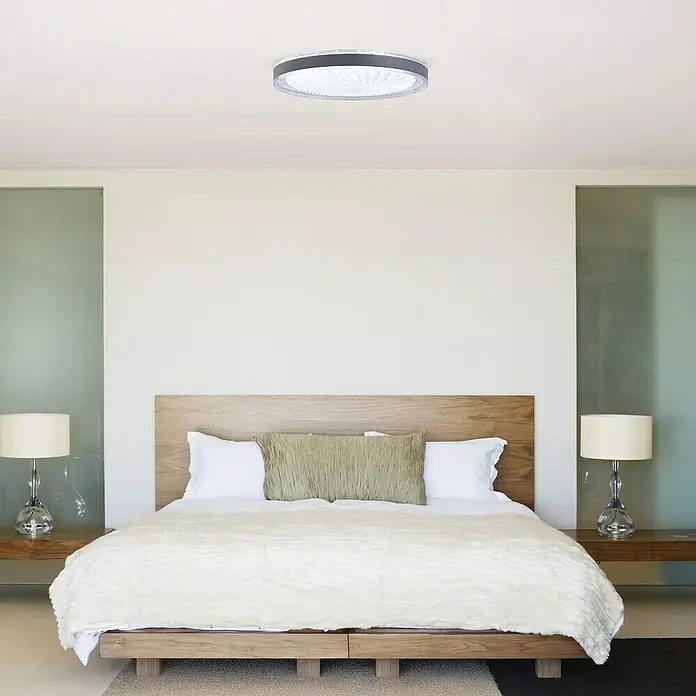 Led Hispania Plafón LED redondo Bisé - 40 W, Ø x Al: 500 cm x 90 mm, Gris/Plata, Blanco frío - Un plafón redondo moderno con marco gris oscuro y difusor blanco texturizado ilumina un dormitorio.
