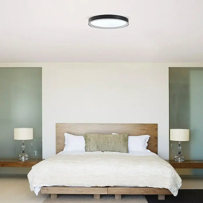 Led Hispania Plafón LED redondo Dokos - 40 W, Ø x Al: 500 cm x 90 mm, Negro, Blanco frío - Lámpara de techo circular blanca y negra instalada en un dormitorio moderno.