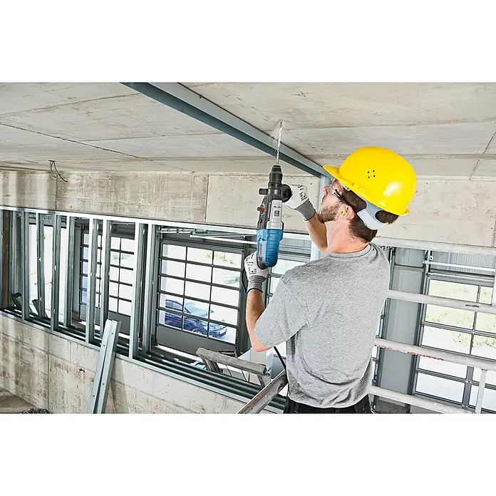 Bosch Professional Bohrhammer GBH 2-28 F - 880 W, 3,2 J, SDS-Plus-Aufnahme - Mann bohrt mit blau-schwarzem Bohrhammer in Betondecke.