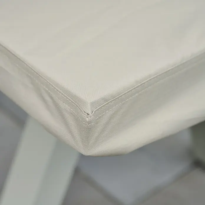 Siena Garden Gartentisch-Schutzhülle PLUS - L x B x H: 200 x 110 x 15 cm, Polyester, TPU laminiert, Beige - Nahaufnahme einer beigefarbenen Stoffabdeckung mit sichtbaren Nähten an einer Ecke.
