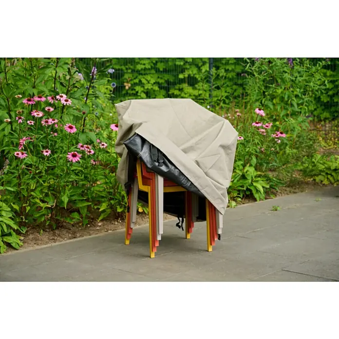 Siena Garden Stapelsessel-Schutzhülle PLUS - L x B x H: 67 x 67 x 110 cm, Polyester, TPU laminiert, Beige - Gestapelte bunte Gartenstühle unter einer beigefarbenen Schutzplane, auf einer Terrasse neben blühenden rosa Sonnenhüten.