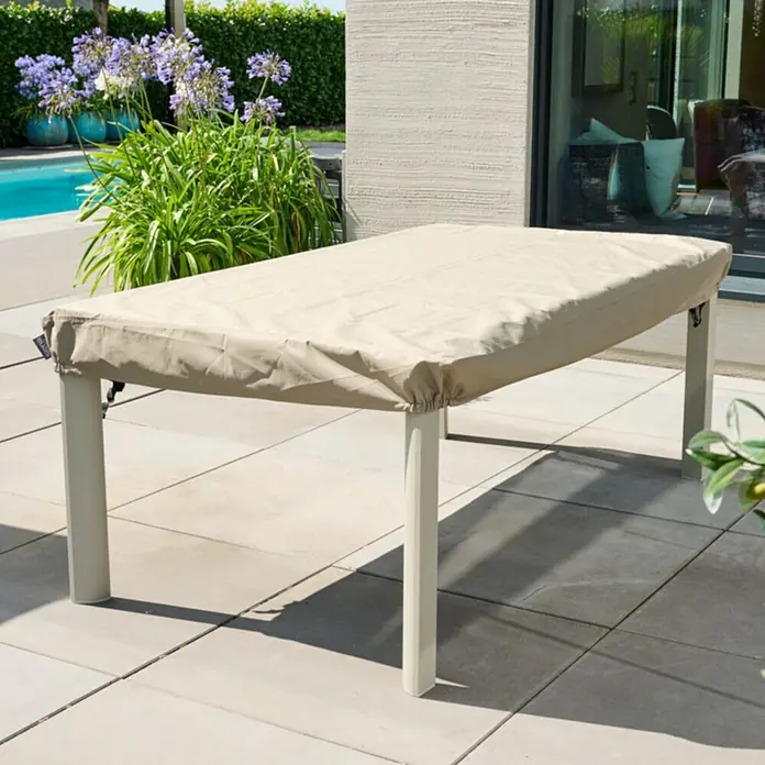 Siena Garden Gartentisch-Schutzhülle PLUS - L x B x H: 240 x 110 x 15 cm, Polyester, TPU laminiert, Beige - Hellbeige Stoffschutzhülle auf einem rechteckigen Gartentisch auf einer Terrasse.