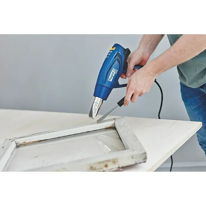 Rapid Heißluftgebläse R2000 - 2.000 W, Temperaturbereich: 60 °C - 600 °C - Heißluftpistole Rapid RP200 mit Farbschaber zum Entfernen alter Farbreste von einem Fensterrahmen. Das Werkzeug ist ideal für Renovierungsarbeiten.