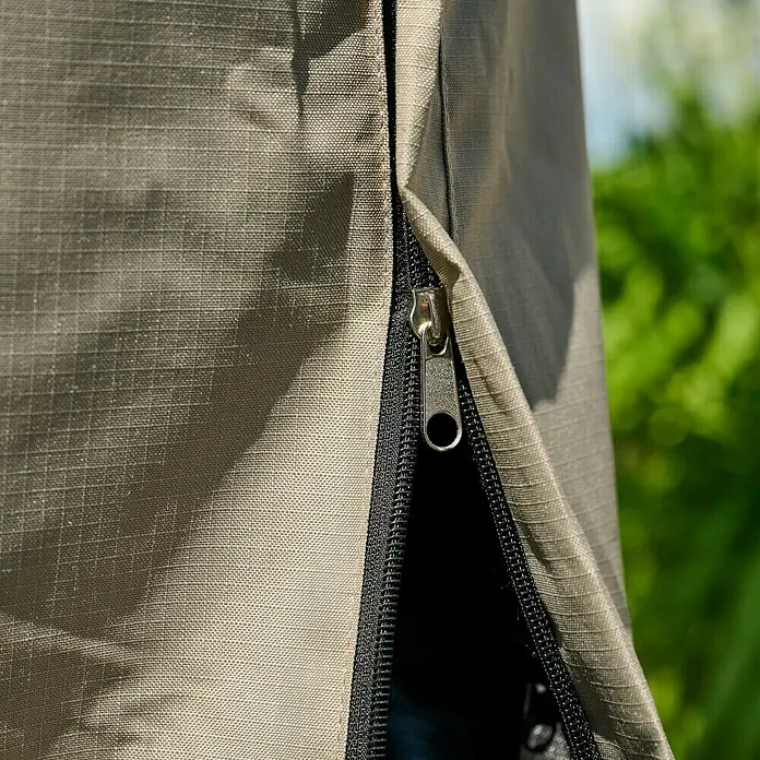 Siena Garden Stapelsessel-Schutzhülle PLUS - L x B x H: 128 x 105 x 160 cm, Polyester, TPU laminiert, Beige - Nahaufnahme eines teilweise geöffneten schwarzen Reißverschlusses mit silbernem Griff an beigem Ripstop-Gewebe.