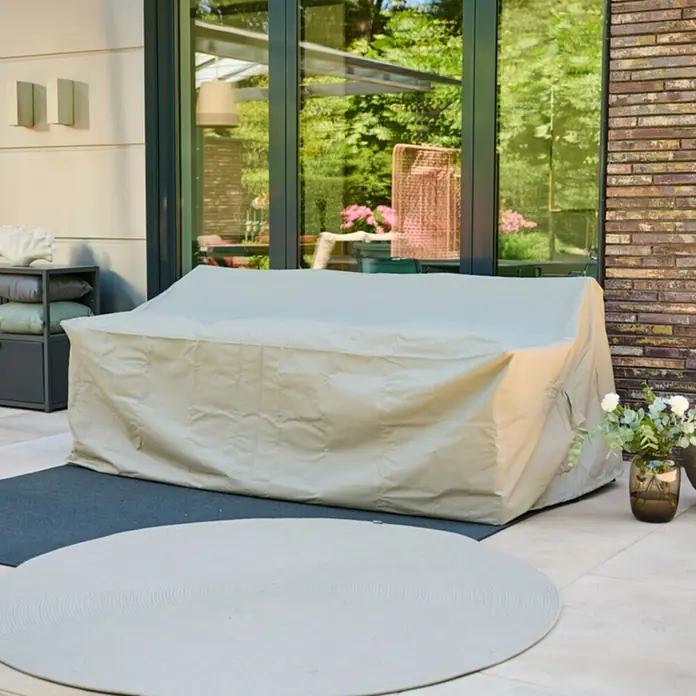 Siena Garden Loungemöbel Schutzhülle PLUS - L x B x H: 205 x 100 x 70 cm, Polyester, TPU laminiert, Beige - Beige Schutzhülle für ein Outdoor-Sofa, auf einer Terrasse platziert.