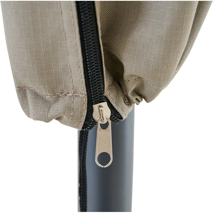 Siena Garden Sonnenschirm Schutzhülle PLUS - Passend für: Schirme mit einem ⌀ bis zu 3,0 m, Polyester, TPU laminiert, Beige - Nahaufnahme einer beigen Ripstop-Stoffabdeckung mit schwarzem Reißverschluss und Messinggriff, die einen dunklen Pfosten umschließt.