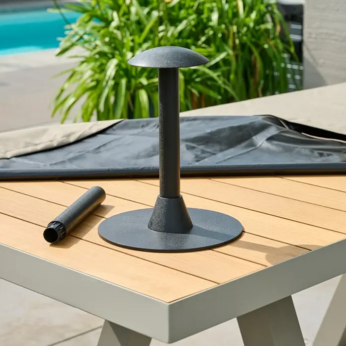 Abstandhalter - Passend für: Gartentische, Polypropylen, Schwarz - Dunkelgrauer Metall-Sonnenschirmständerteil und separates Rohr auf Holztisch.