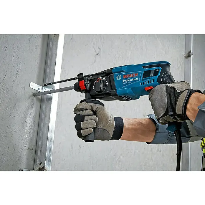 Bosch Professional Bohrhammer GBH 2-21 - 720 W, 2 J, SDS-Plus-Aufnahme - Blauer Bosch GBH 2-21 Bohrhammer wird von behandschuhten Händen in eine Betonwand gebohrt.
