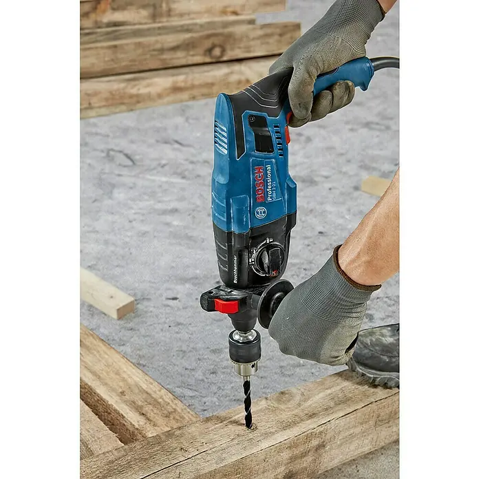 Bosch Professional Bohrhammer GBH 2-21 - 720 W, 2 J, SDS-Plus-Aufnahme - Blauer und schwarzer Bosch Bohrhammer im Einsatz, bohrt in Holz.