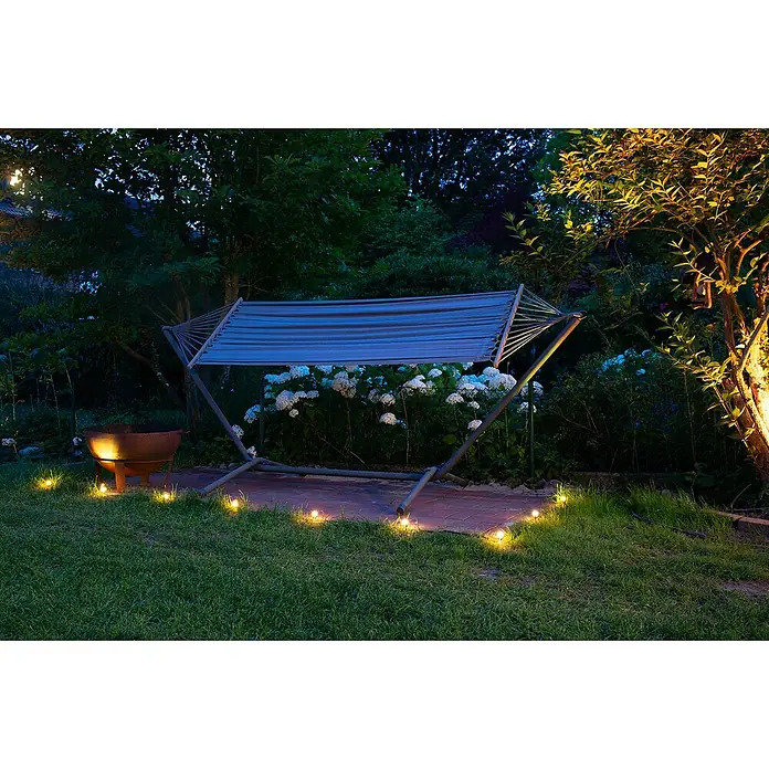 Ledvance LED-Lichterkette Endura Dot - Außen, 9,25 m, Lichtfarbe: Warmweiß, Anzahl Leuchtmittel: 9 Stk. - Gestreifte Hängematte auf Metallgestell, nachts in einem gemütlichen Garten beleuchtet.
