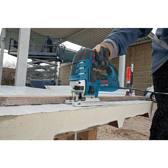 Bosch Professional Elektro-Stichsäge GST 150 CE - 500 /min - 3.100 /min, 150 mm - Eine Person schneidet mit einer blau-schwarzen Bosch Professional Stichsäge eine dicke Isolierplatte auf einer Baustelle.