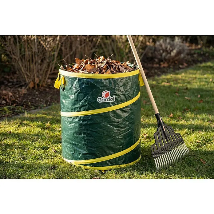 Gardol Pop-Up Gartenabfallsack - 80 l, Höhe: 48 cm, Durchmesser: 46 cm - Grüne Gardol Gartenabfallsack, gefüllt mit braunen Blättern, daneben ein Rechen.