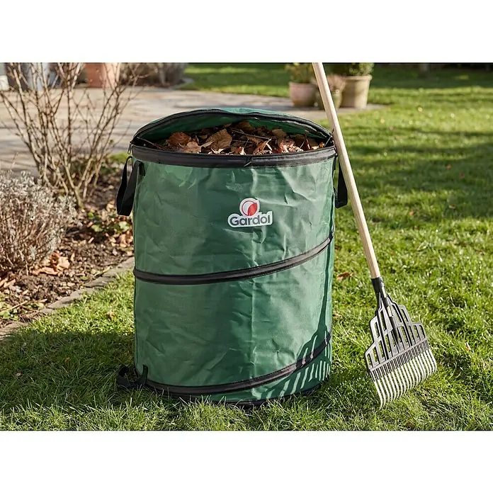 Gardol Premium Pop-Up Gartenabfallsack - 80 l, Ø x H: 46 x 48 cm - Grüner Gardol Gartenabfallsack, gefüllt mit trockenem Laub, mit einer Harke auf Rasen.