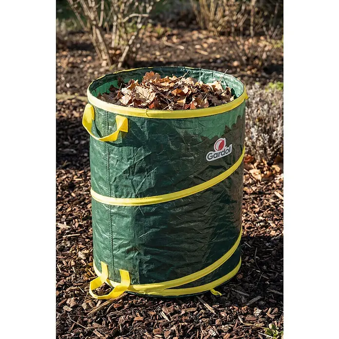 Gardol Pop-Up Gartenabfallsack - 120 l, Höhe: 60 cm, Durchmesser: 50 cm - Grüner, zusammenklappbarer Gartenabfallsack mit gelben Griffen, gefüllt mit trockenem Laub, auf Rindenmulch.