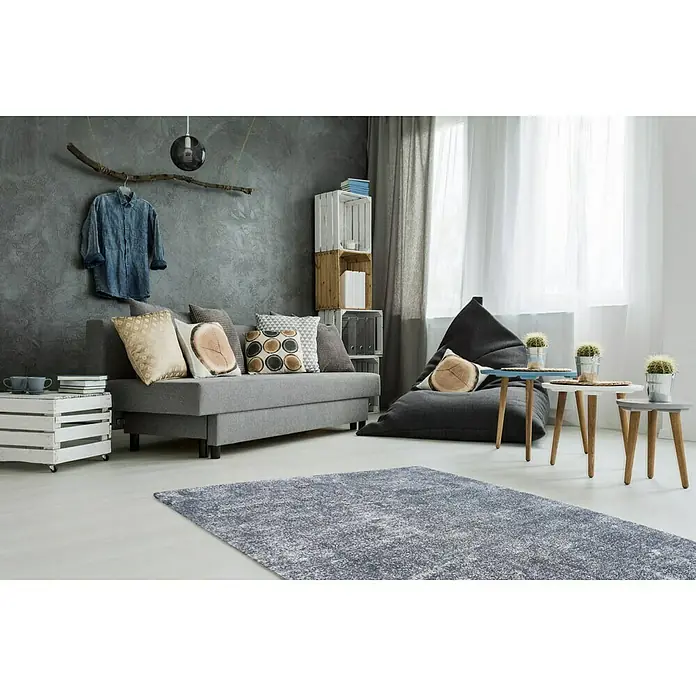 Kayoom Kurzflorteppich Etna - Hellblau, 230 x 160 cm, 100 % Mikropolyester - Ein stilvoller Wohnraum mit einem grauen Teppich, der den Raum optisch aufwertet und für Komfort sorgt.