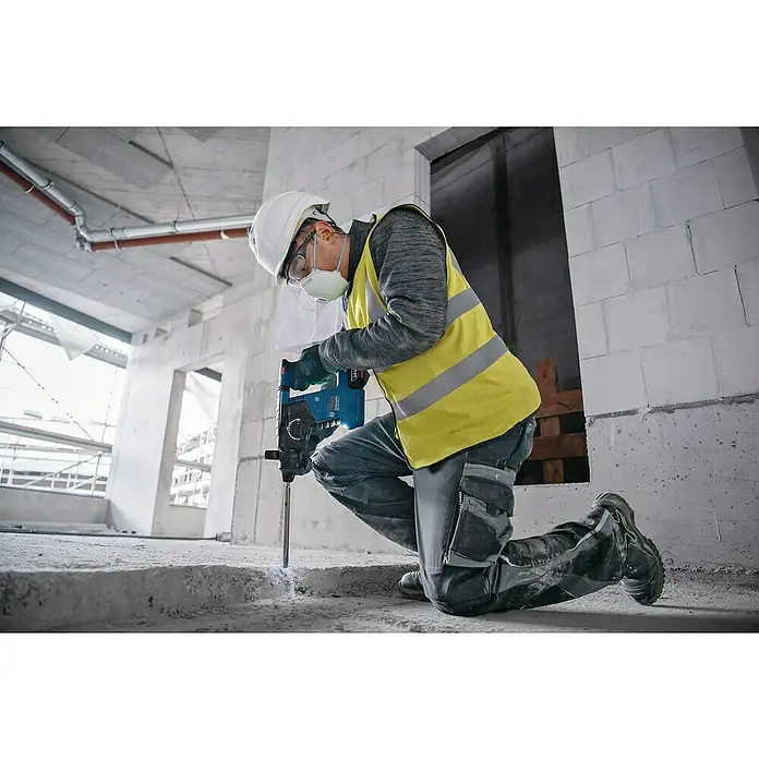 Bosch Professional AMPShare 18V Akku-Kombihammer GBH 18V-24 C - 18 V, Ohne Akku, 2,4 J - Blauer und schwarzer 18V Akku-Bohrhammer, der von einem Arbeiter zum Bohren in Beton auf einer Baustelle verwendet wird.