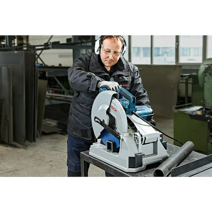 Bosch Metallkreissäge GCD 12 JL - 2.000 W, Leerlaufdrehzahl: 1.500 U/min - Blaugraue Bosch Trennsäge im Einsatz, ein Arbeiter schneidet Metallprofile in einer Werkstatt.